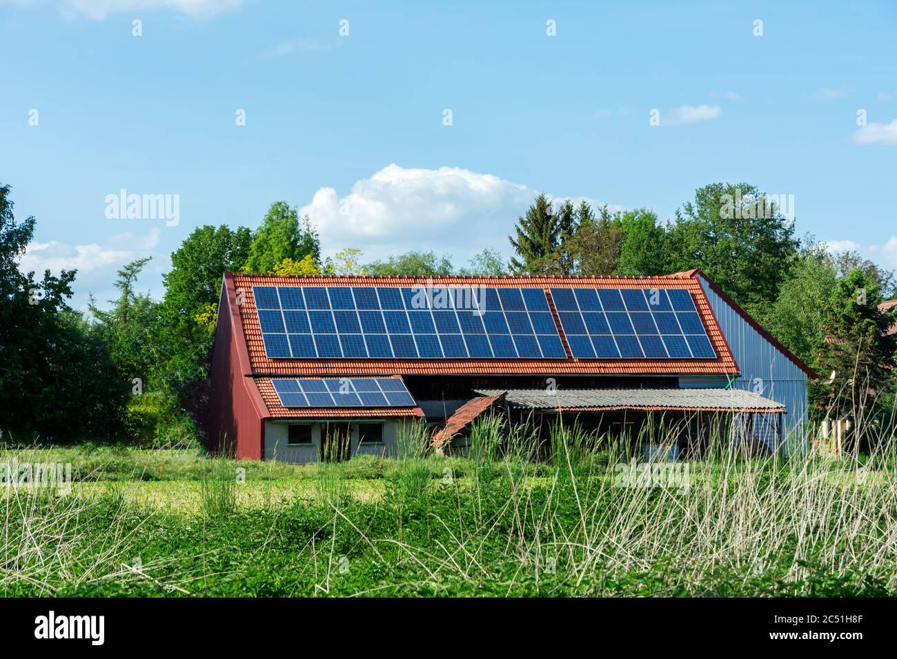 Energia Verde con collettori solari sul tetto di un edificio agricolo Foto Stock