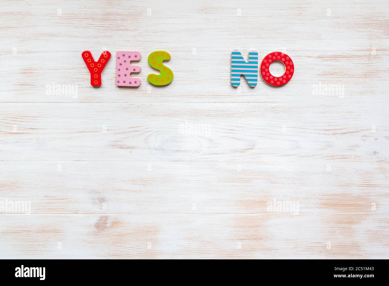Parole sì e NO di lettere colorate su sfondo di legno d'epoca. Parole colorate sì e NO su sfondo di legno con spazio di copia. Scegliere la risposta giusta Foto Stock