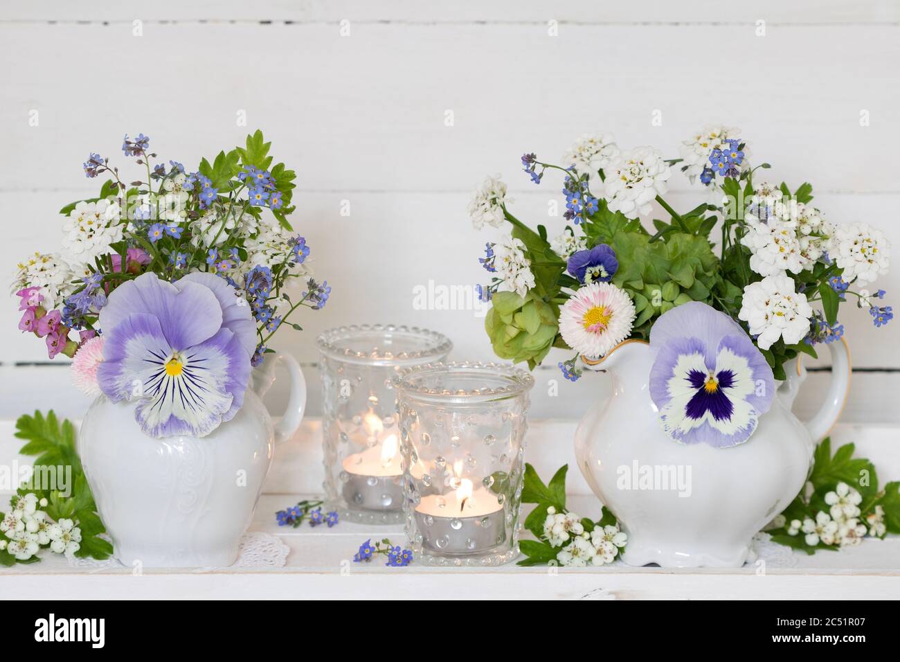 mazzi di fiori di primavera in blu e bianco in lattine di latte Foto Stock