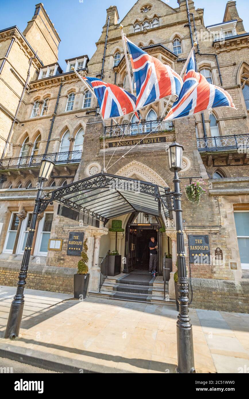 Ian, uno dei dirigenti, pulisce le maniglie delle porte anteriori del Randolph Hotel, Oxford, pronto per riaprire dopo il blocco Covid-19 il 4 luglio 2020 Foto Stock