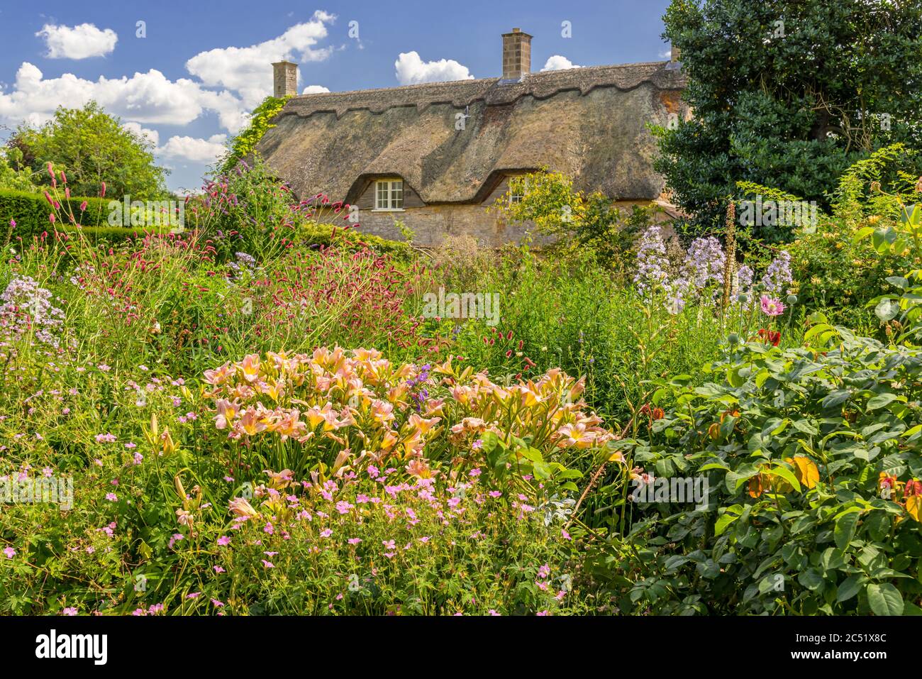 Tipico giardino cottage di fronte ad un tipico cottage di campagna Foto Stock