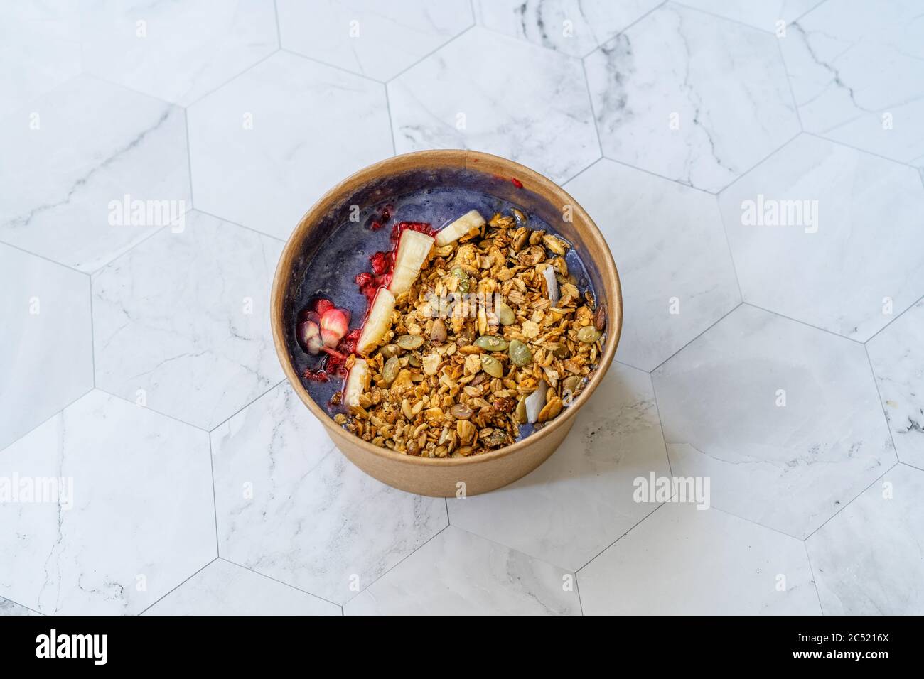 Ciotola Matcha blu con granola, mirtilli e banana / Smoothie Spirulina Blu sana in scatola di cartone Kraft di carta marrone. Supercibo sano organico. Foto Stock