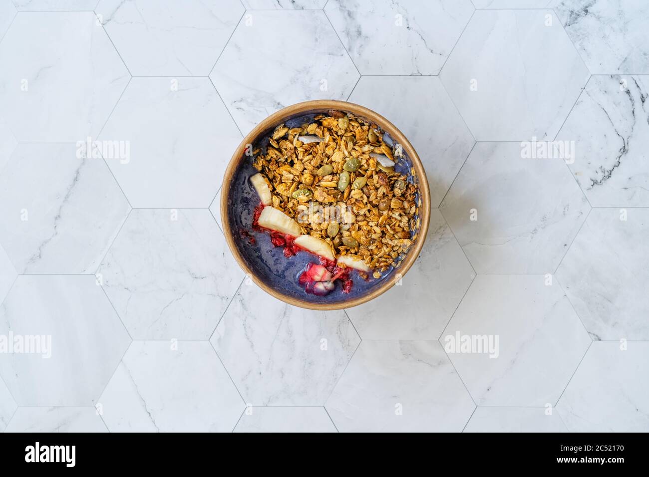 Ciotola Matcha blu con granola, mirtilli e banana / Smoothie Spirulina Blu sana in scatola di cartone Kraft di carta marrone. Supercibo sano organico. Foto Stock
