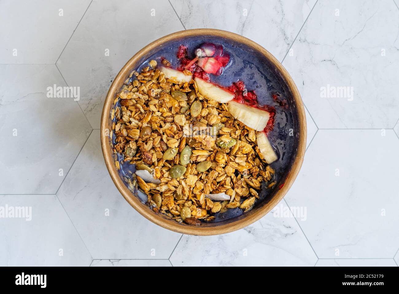 Ciotola Matcha blu con granola, mirtilli e banana / Smoothie Spirulina Blu sana in scatola di cartone Kraft di carta marrone. Supercibo sano organico. Foto Stock
