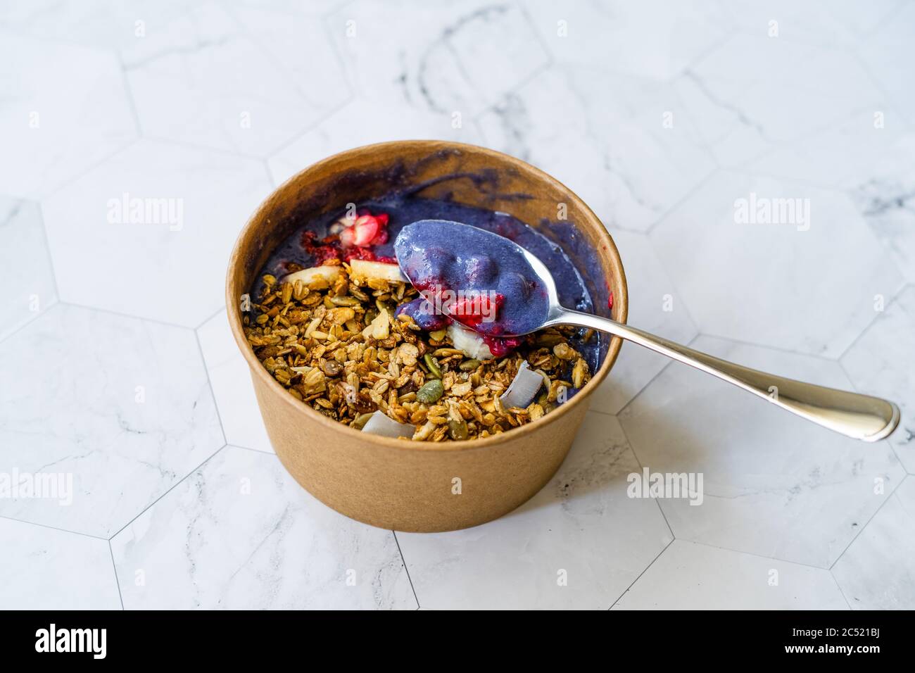 Ciotola Matcha blu con granola, mirtilli e banana / Smoothie Spirulina Blu sana in scatola di cartone Kraft di carta marrone. Supercibo sano organico. Foto Stock