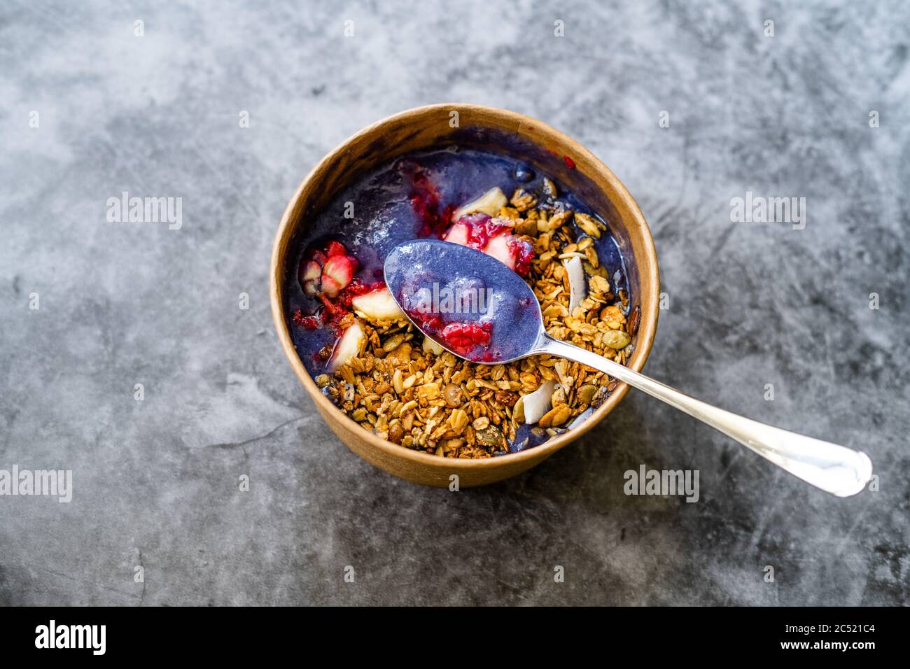 Ciotola Matcha blu con granola, mirtilli e banana / Smoothie Spirulina Blu sana in scatola di cartone Kraft di carta marrone. Supercibo sano organico. Foto Stock
