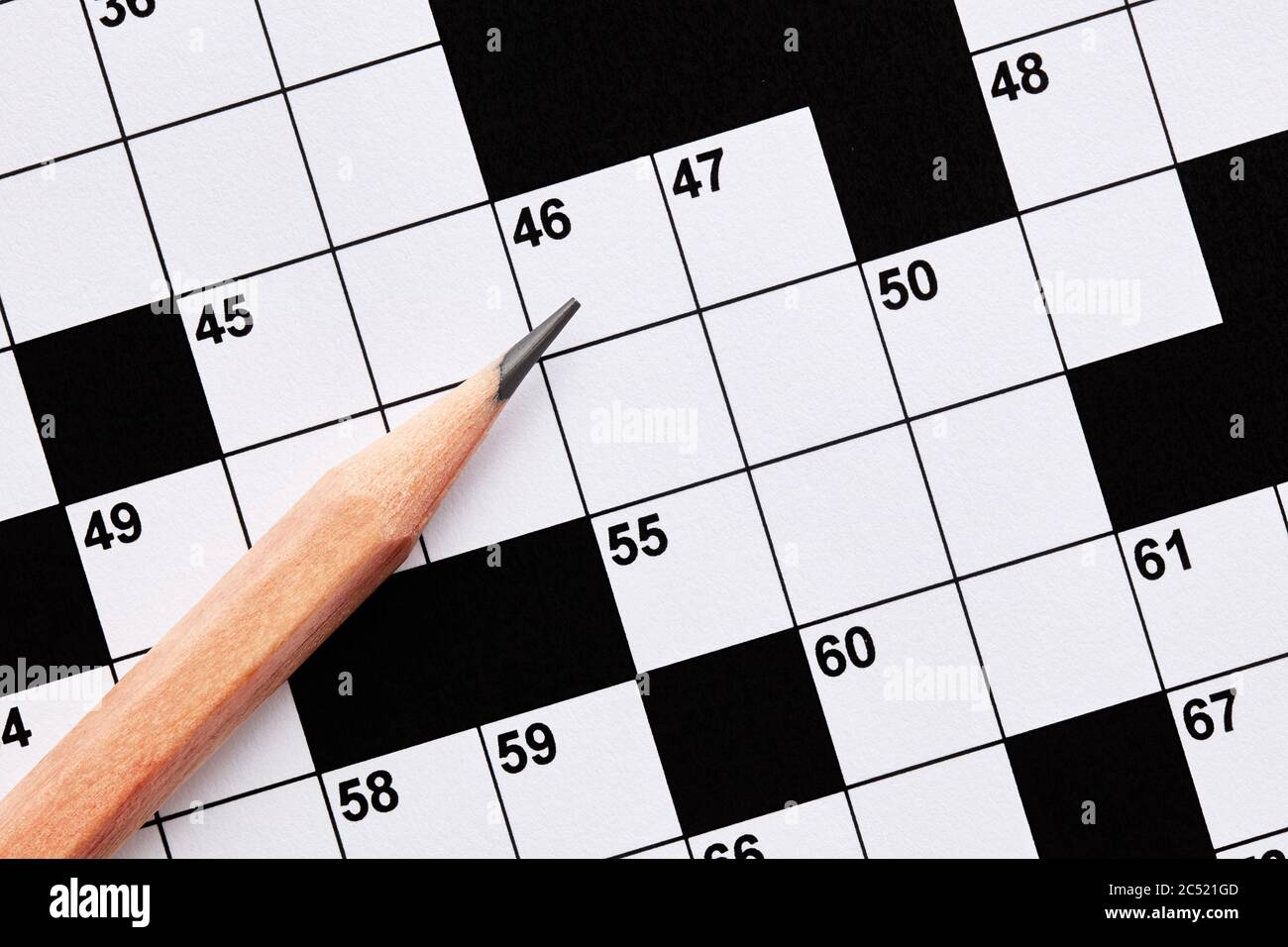 Gioco di puzzle crossword vuoto con matita. Vista ravvicinata dall'alto. Foto Stock
