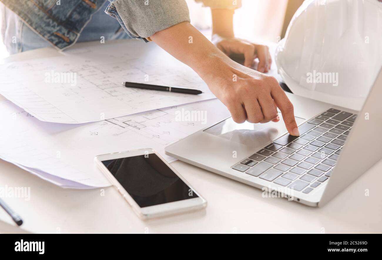 Panoramica di ingegneri o architetti che utilizzano un computer portatile per pianificare i progetti. Progettazione e costruzione. Foto Stock