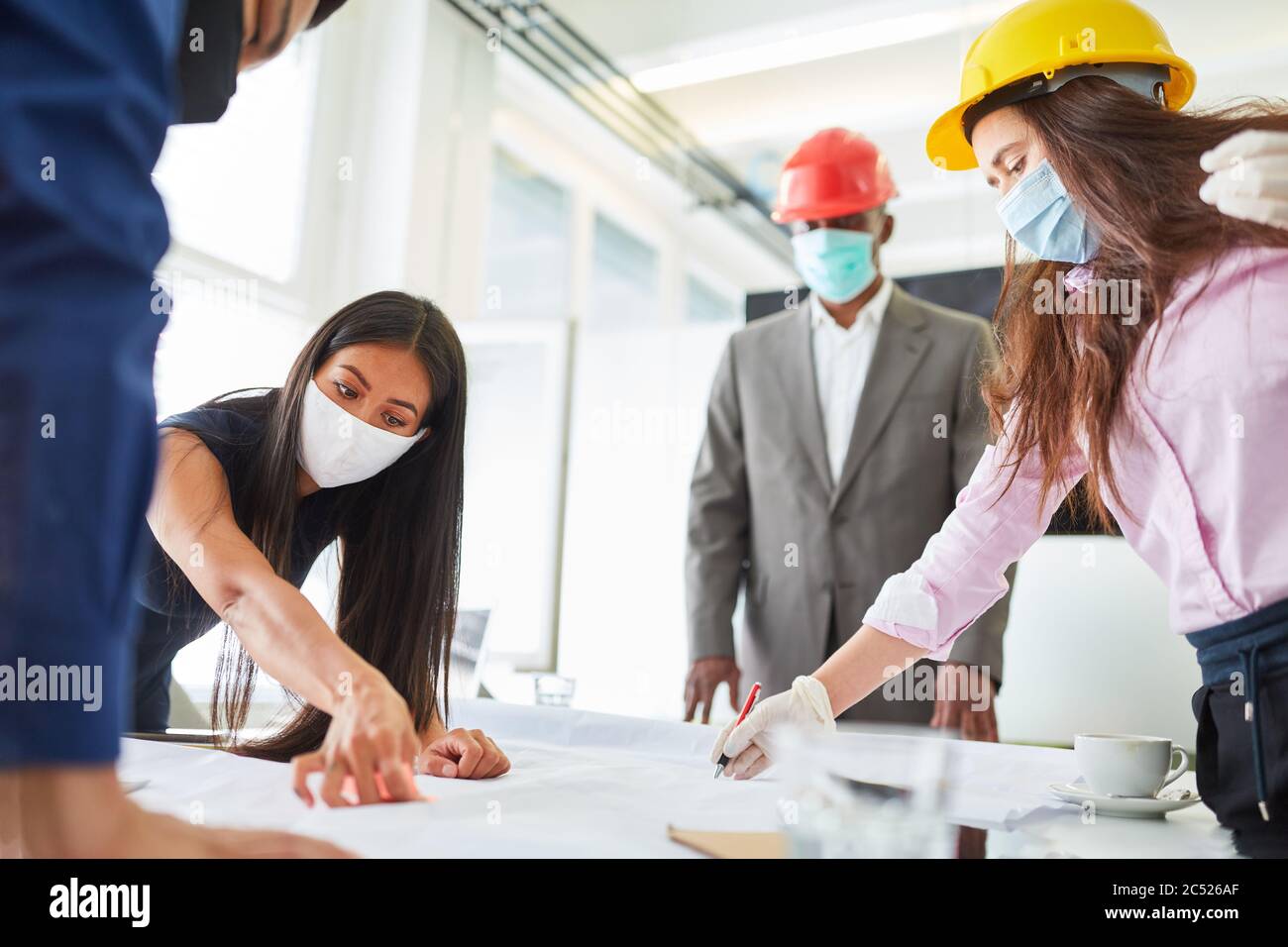 Architetti e uomini d'affari con maschera facciale a causa di Covid-19 in una riunione di pianificazione Foto Stock