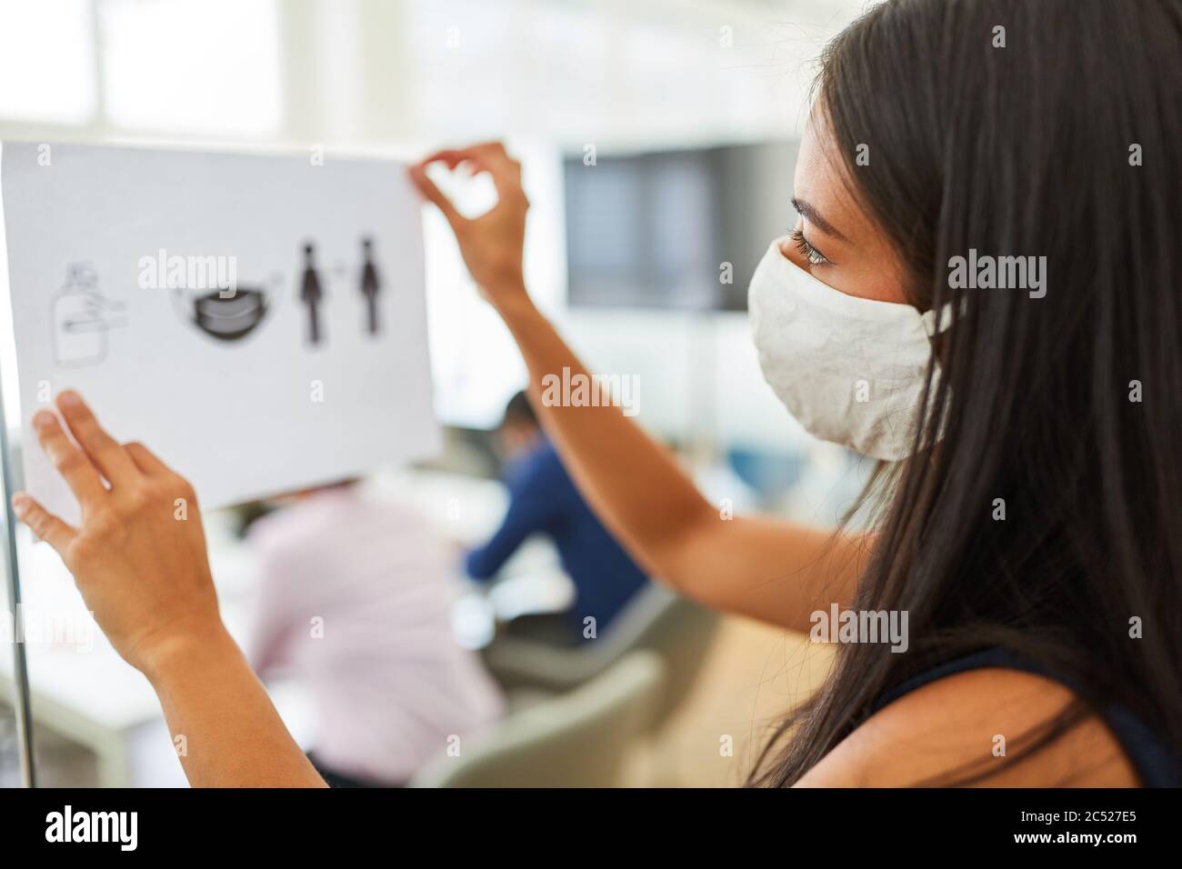Donna di affari con maschera di faccia fissa le note con le regole di igiene come prevenzione contro l'infezione Foto Stock