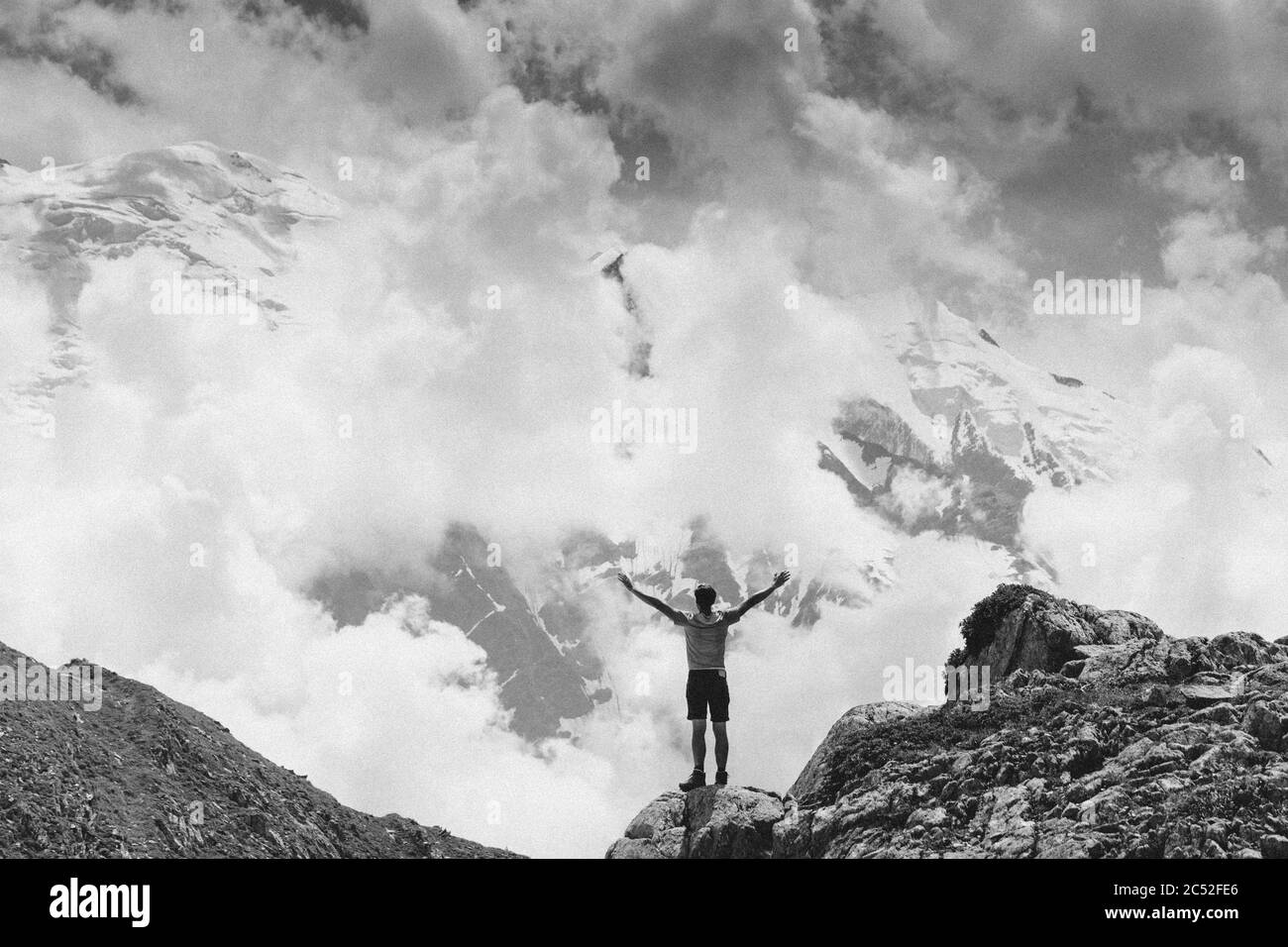 Uomo in piedi sulla cima della montagna con le sue braccia distese, Monte Bianco, alta Savoia, Auvergne-Rodano-Alpi, Francia Foto Stock