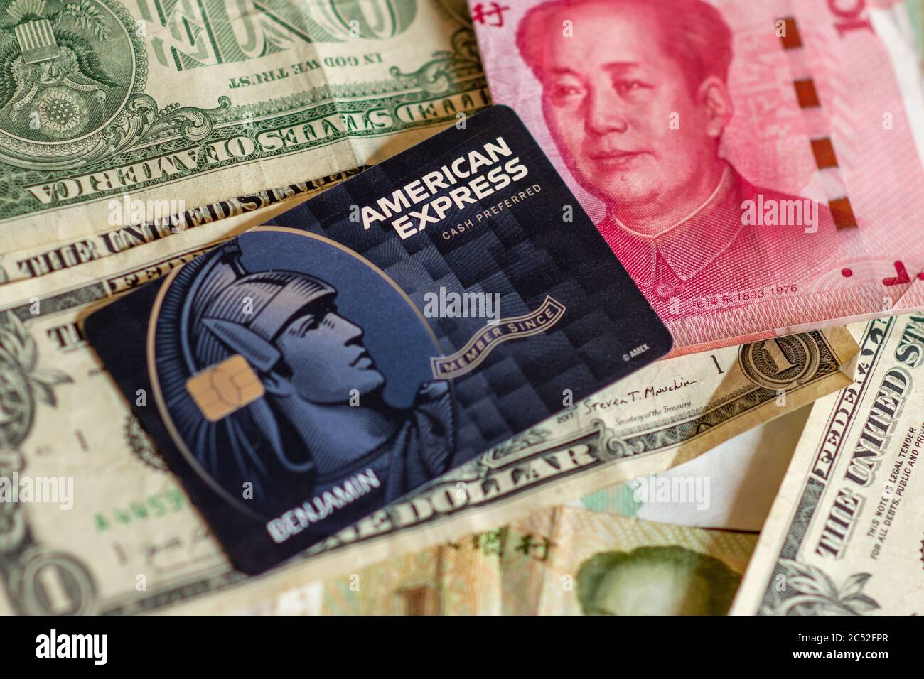 Washington, DC/ USA - Giugno 23 2020: Carta di credito American Express con sfondo Yuan Cinese (RMB) e dollari USA Foto Stock