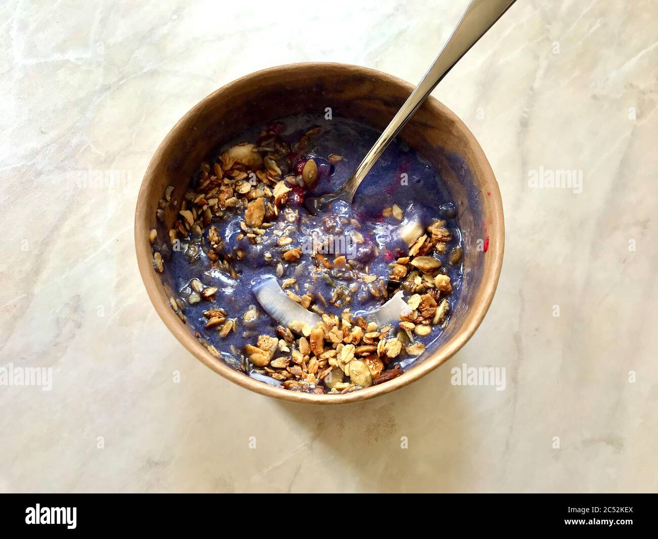 Ciotola Matcha blu con granola, mirtilli e banana / Smoothie Spirulina Blu sana in scatola di cartone Kraft di carta marrone. Supercibo sano organico. Foto Stock