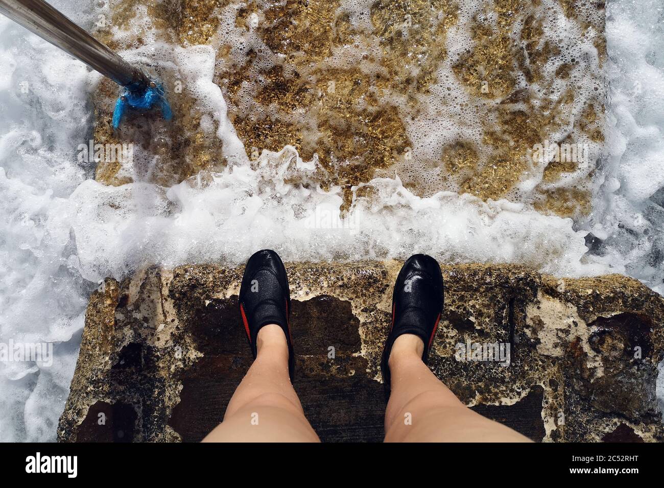 Donna che indossa scarpe da nuoto in piedi sui gradini del mare, Bugibba,  Malta Foto stock - Alamy