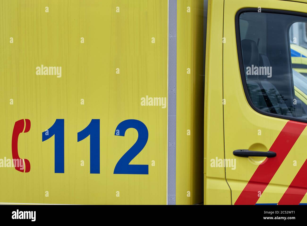 Primo piano di un furgone giallo con numero di telefono tedesco di emergenza 112 Foto Stock