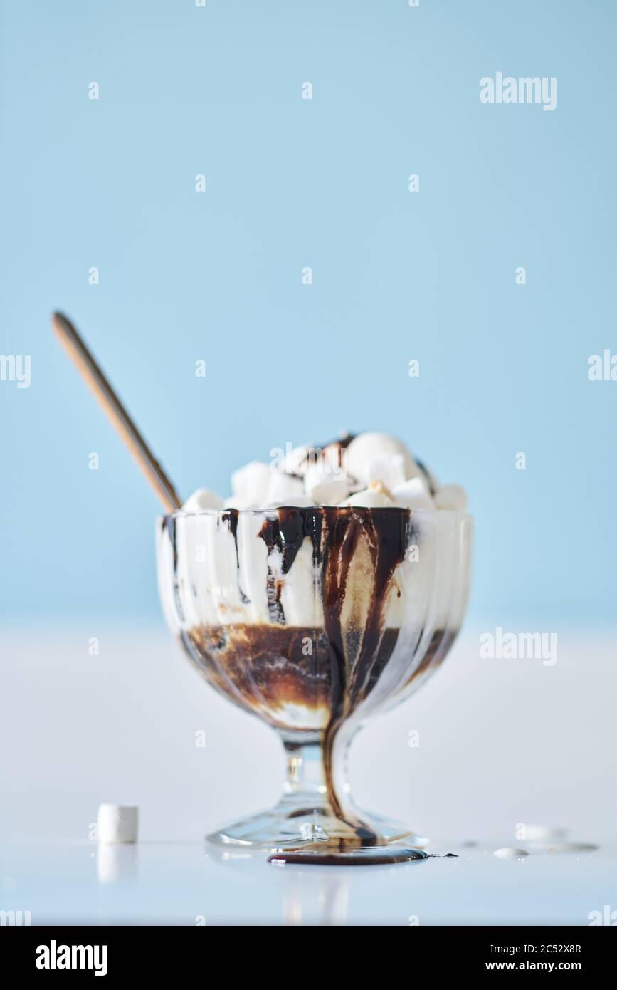 Frullato con condimento al cioccolato in una tazza da cocktail in vetro, decorata con marshmallows Foto Stock