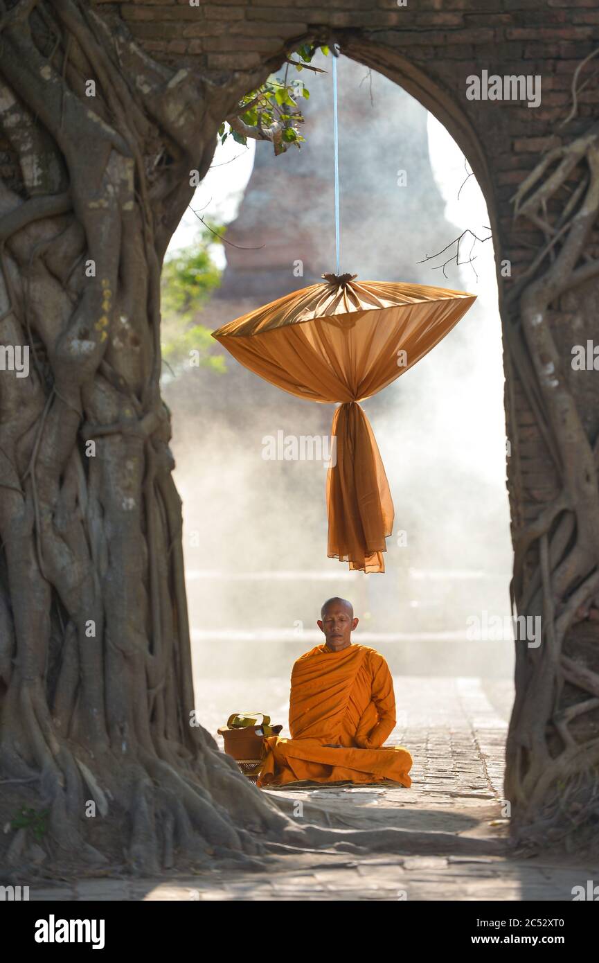 Monaco buddista seduto in un tempio meditating, Thailandia Foto Stock