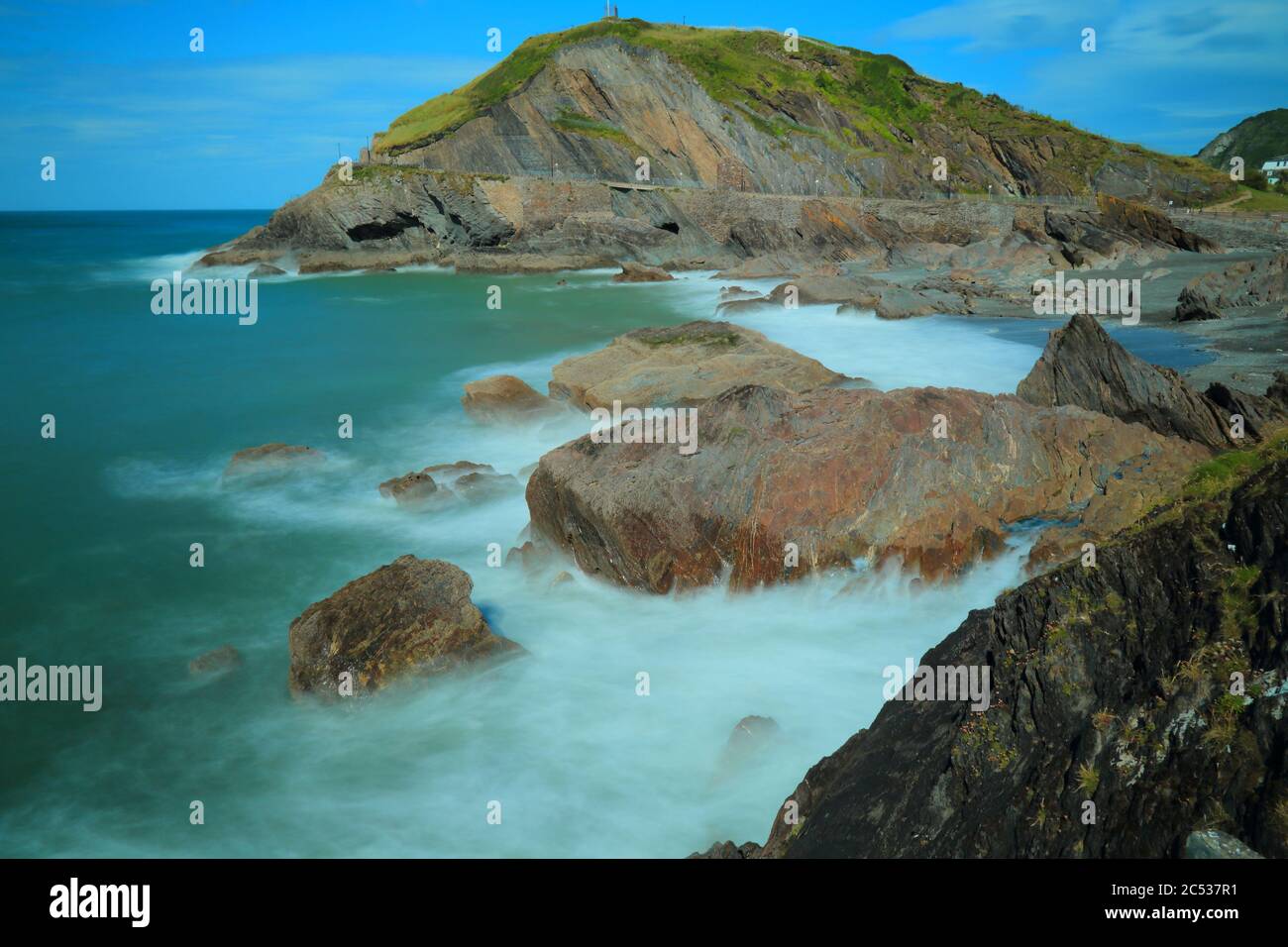 Rocce circondate da onde di mare sfocate sulla costa nord del Devon, Inghilterra Foto Stock