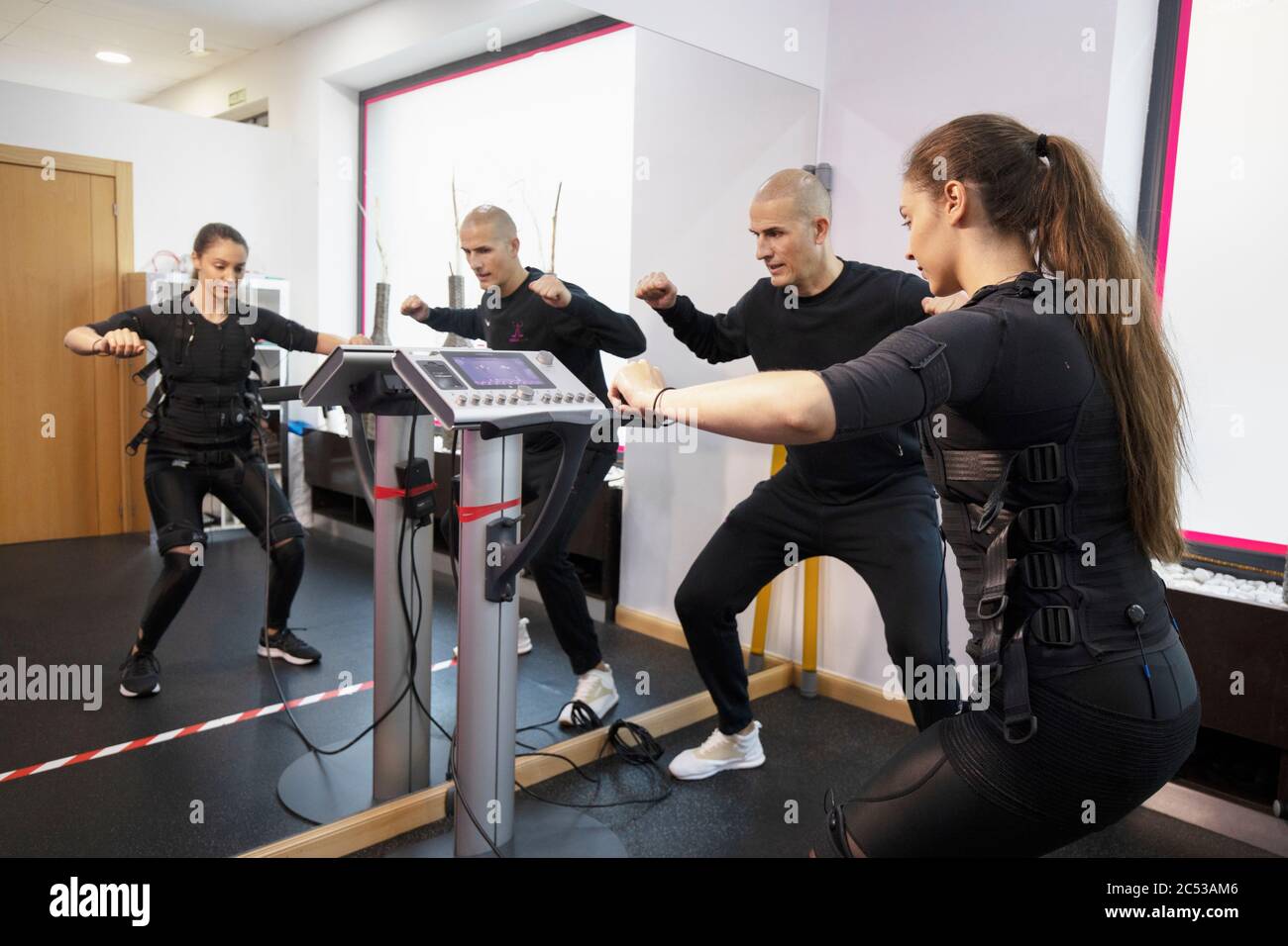 giovane donna allenarsi con il suo personal trainer in interni Foto Stock