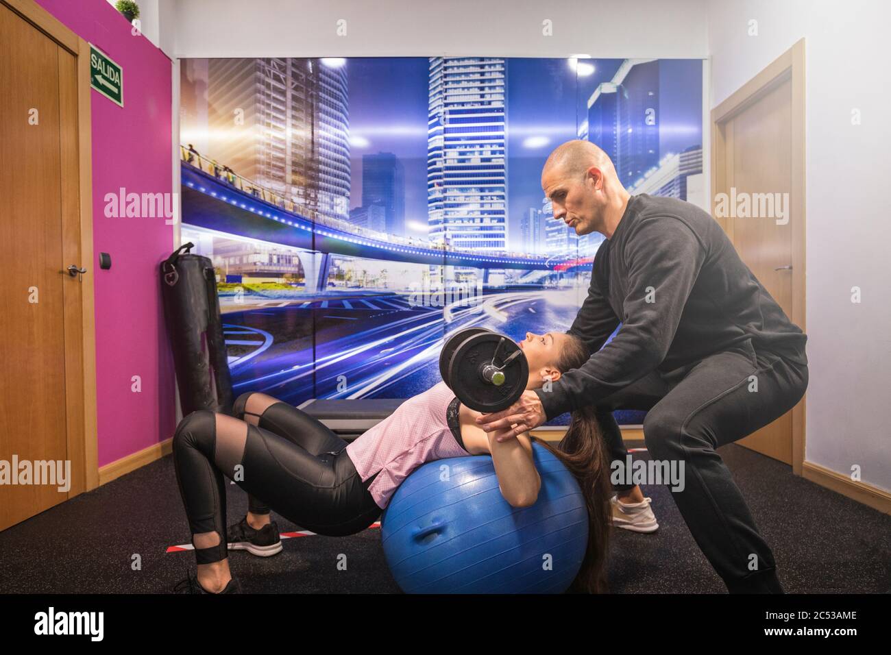 giovane donna allenarsi con il suo personal trainer in interni Foto Stock