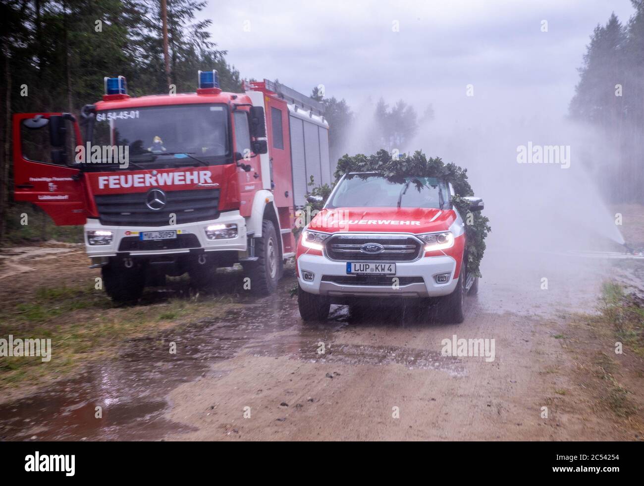Alt Jabel, Germania. 30 giugno 2020. Un nuovo motore antincendio è messo in funzione con una doccia ad acqua. Un anno dopo gli incendi boschivi nella regione, il governo dello stato incontra vigili del fuoco e soccorritori. Un anno fa, i vigili del fuoco, la polizia e la Bundeswehr hanno dovuto spegnere un grande incendio forestale per giorni. Il 26 giugno 2019, il più grande incendio forestale nella storia del Meclemburgo-Vorpommern era scoppiato su più di 400 ettari di un'ex area di addestramento militare. Credit: Jens Büttner/dpa-Zentralbild/ZB/dpa/Alamy Live News Foto Stock