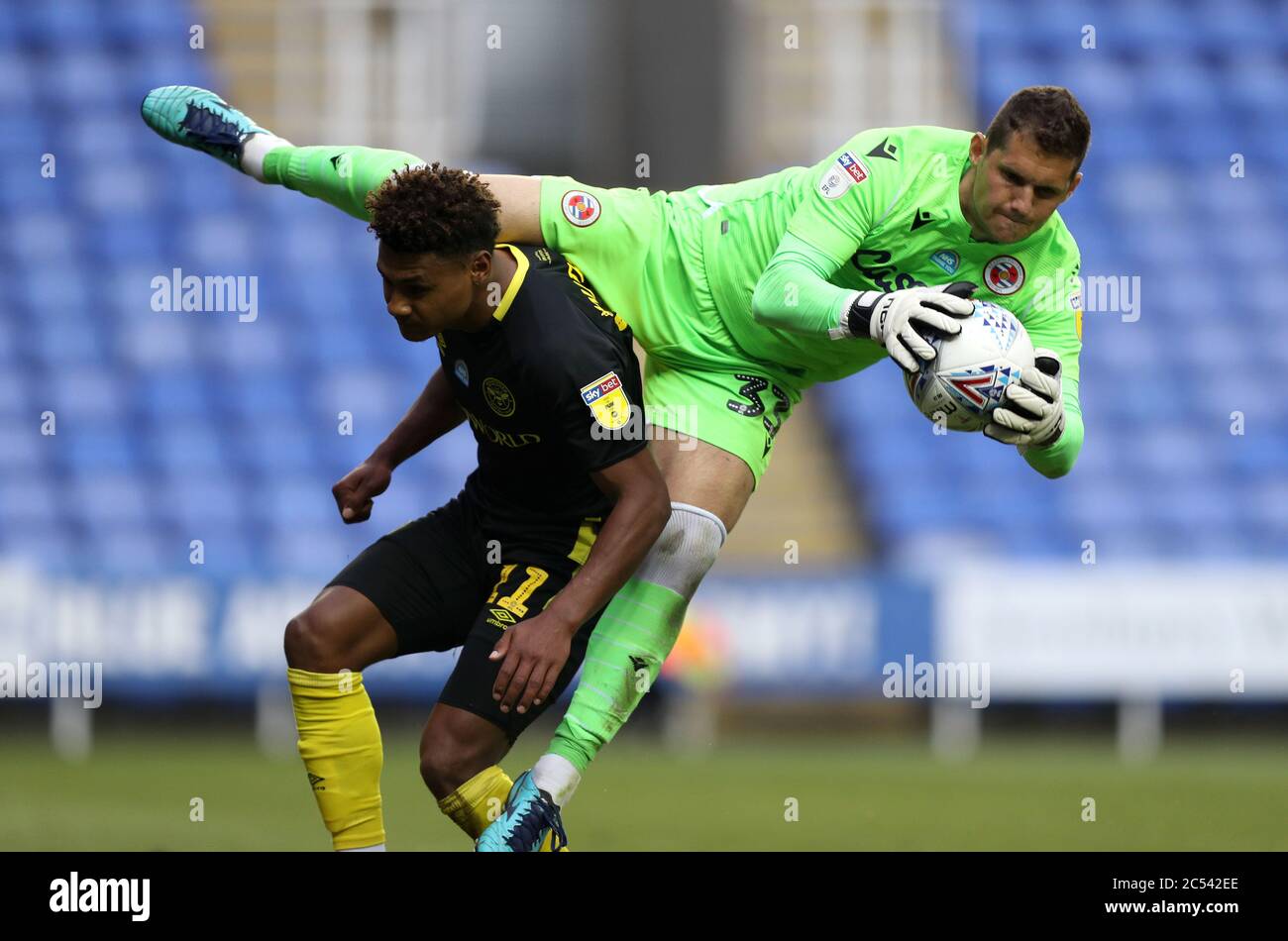 Reading's Rafael Cabral Barbosa si fa da palla su Ollie Watkins di Brentford (a sinistra) durante la partita del campionato Sky Bet allo stadio Madejski di Reading. Foto Stock