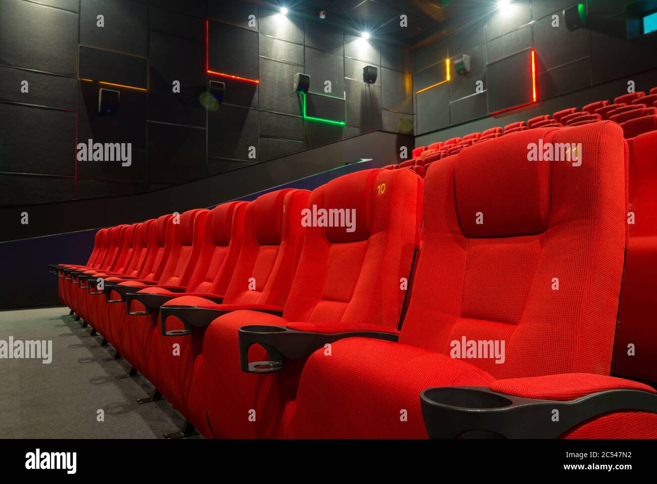 Mosca - 28 agosto 2013: Posti a sedere rossi moderni in primo piano nel cinema. Poltrone confortevoli in una lussuosa sala cinematografica vuota. Fila dei posti del pubblico. Contem Foto Stock