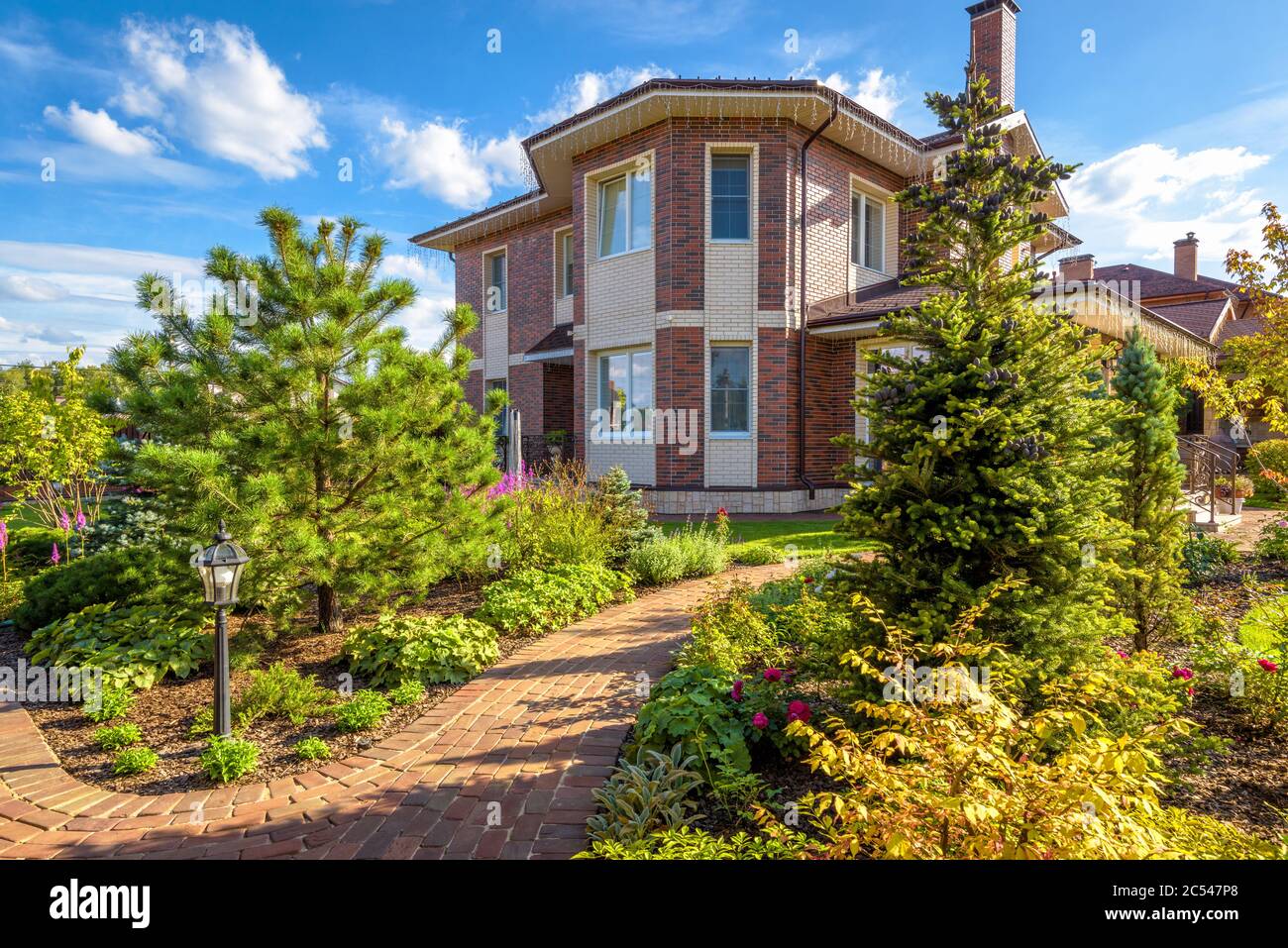 Regione di Mosca - 24 agosto 2019: Progettazione del paesaggio in casa residenziale. Bellissimo paesaggio con percorso lastricato in giardino. Vista panoramica del paesaggio ga Foto Stock