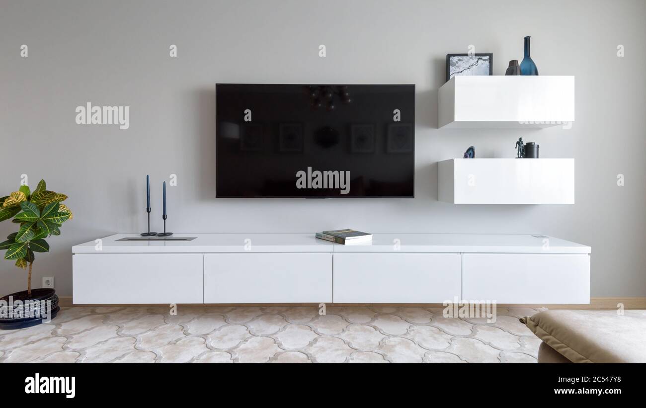 Mosca - 18 giugno 2018: Interni moderni con TV e fiore. Design interno luminoso del soggiorno. Vista panoramica dell'elegante bianco minimalista Foto Stock