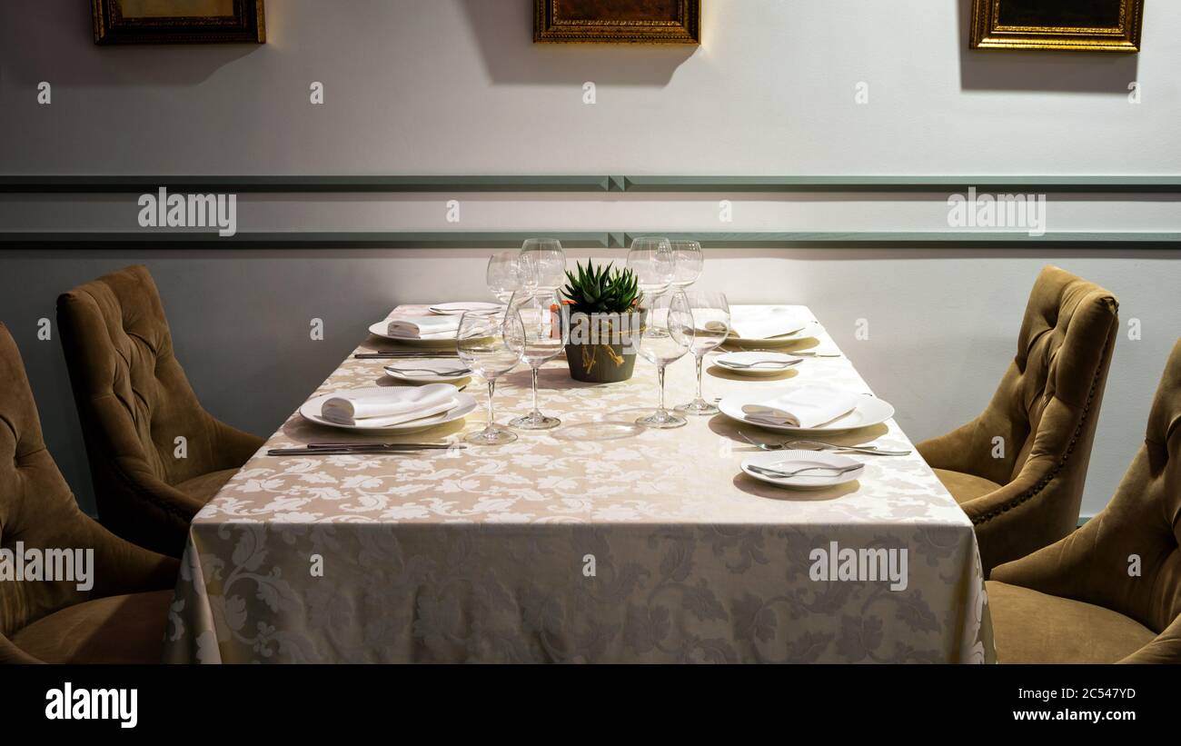 Tavolo in ristorante urbano o bar closeup. Interni classici di un'accogliente caffetteria con un tavolo servito contro le pareti. Illuminazione intima e piacevole. Foto Stock