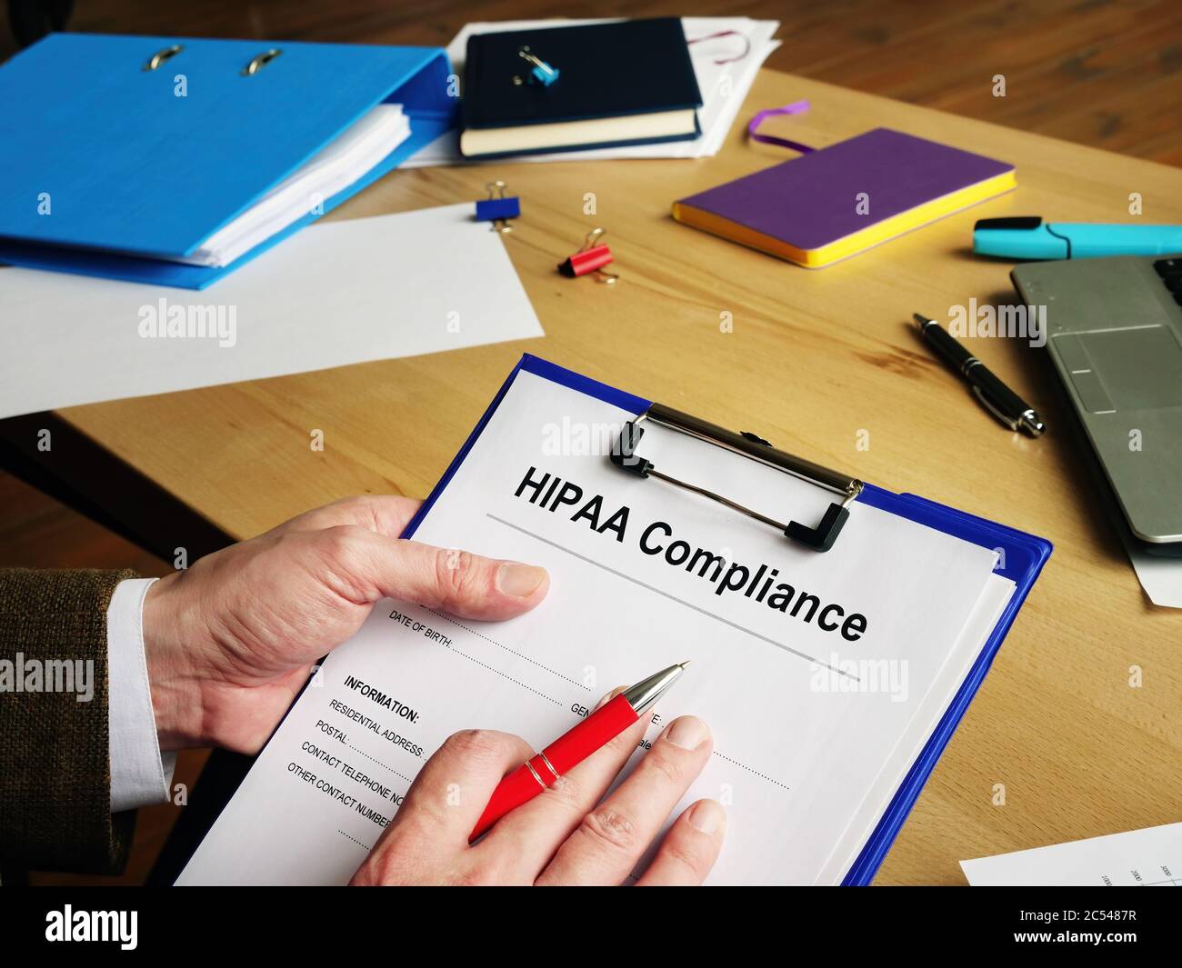 L'impiegato legge documenti sulla conformità HIPAA. Foto Stock