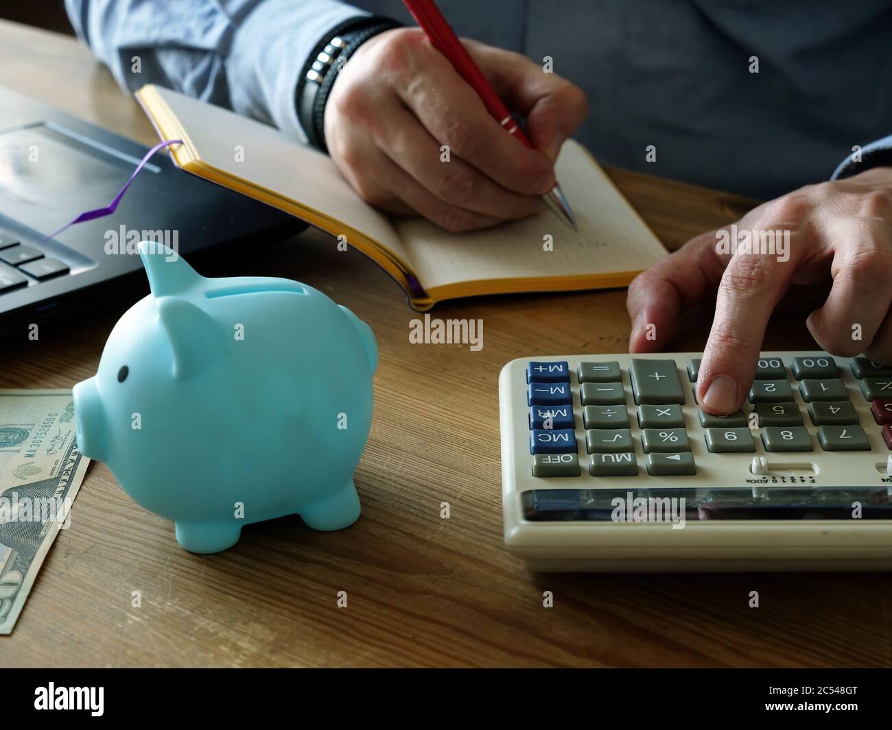 Home Finance. Un uomo che calcola le spese mensili e i risparmi. Foto Stock