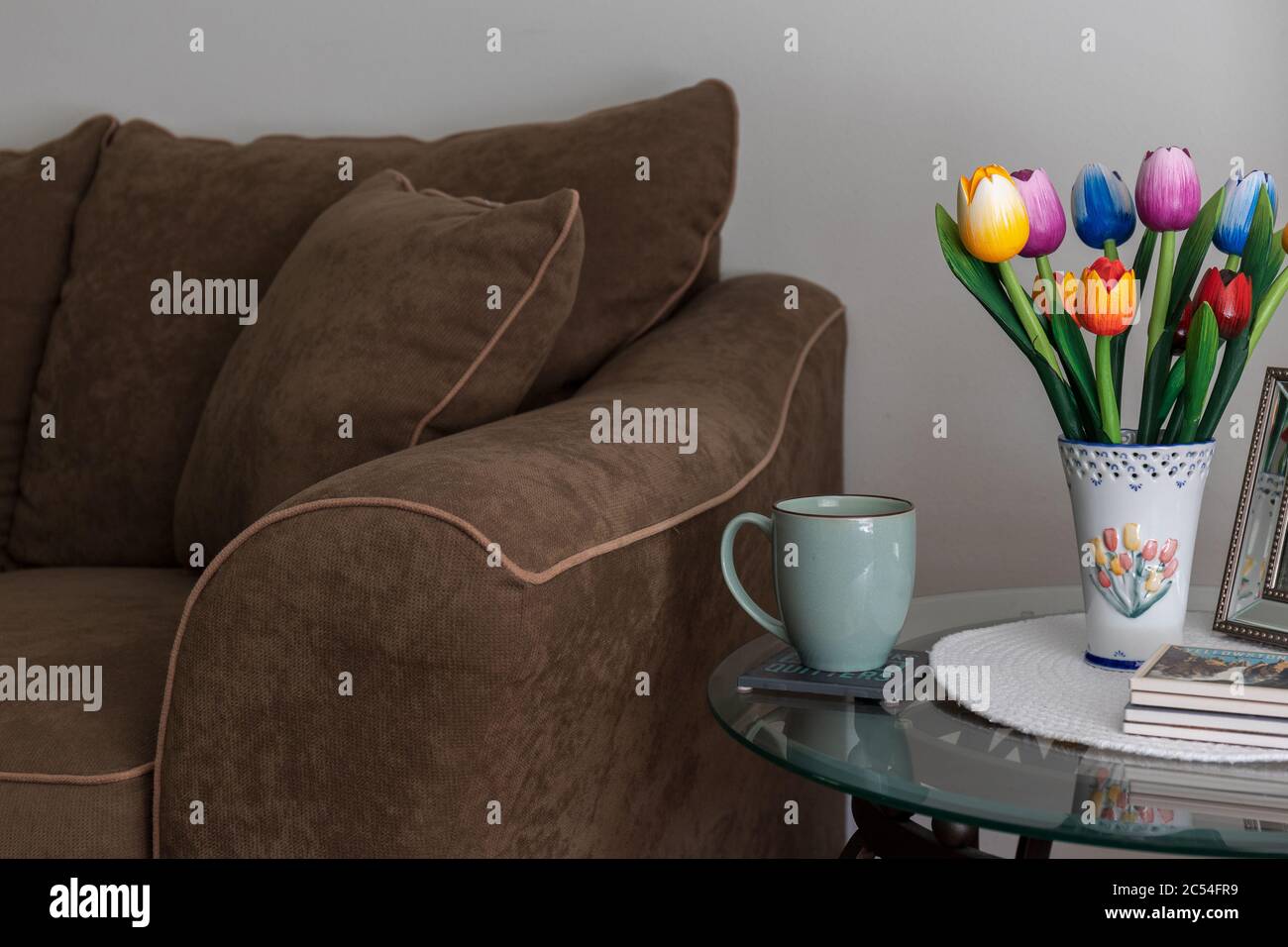 Design interno del soggiorno con divano, tavolo finale e vaso con decorazione floreale Foto Stock