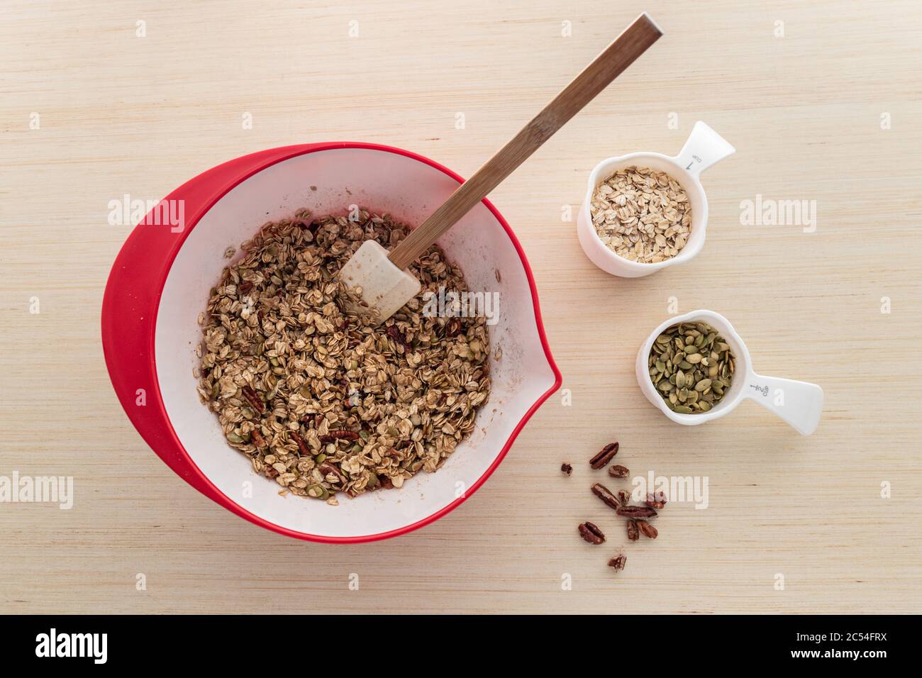 Ingredienti per la preparazione di muesli fatti in casa con avena, semi di zucca e pecan Foto Stock