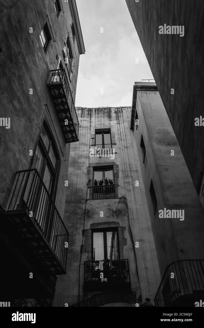 Immagine verticale a basso angolo in scala di grigi degli edifici residenziali con balconi Foto Stock