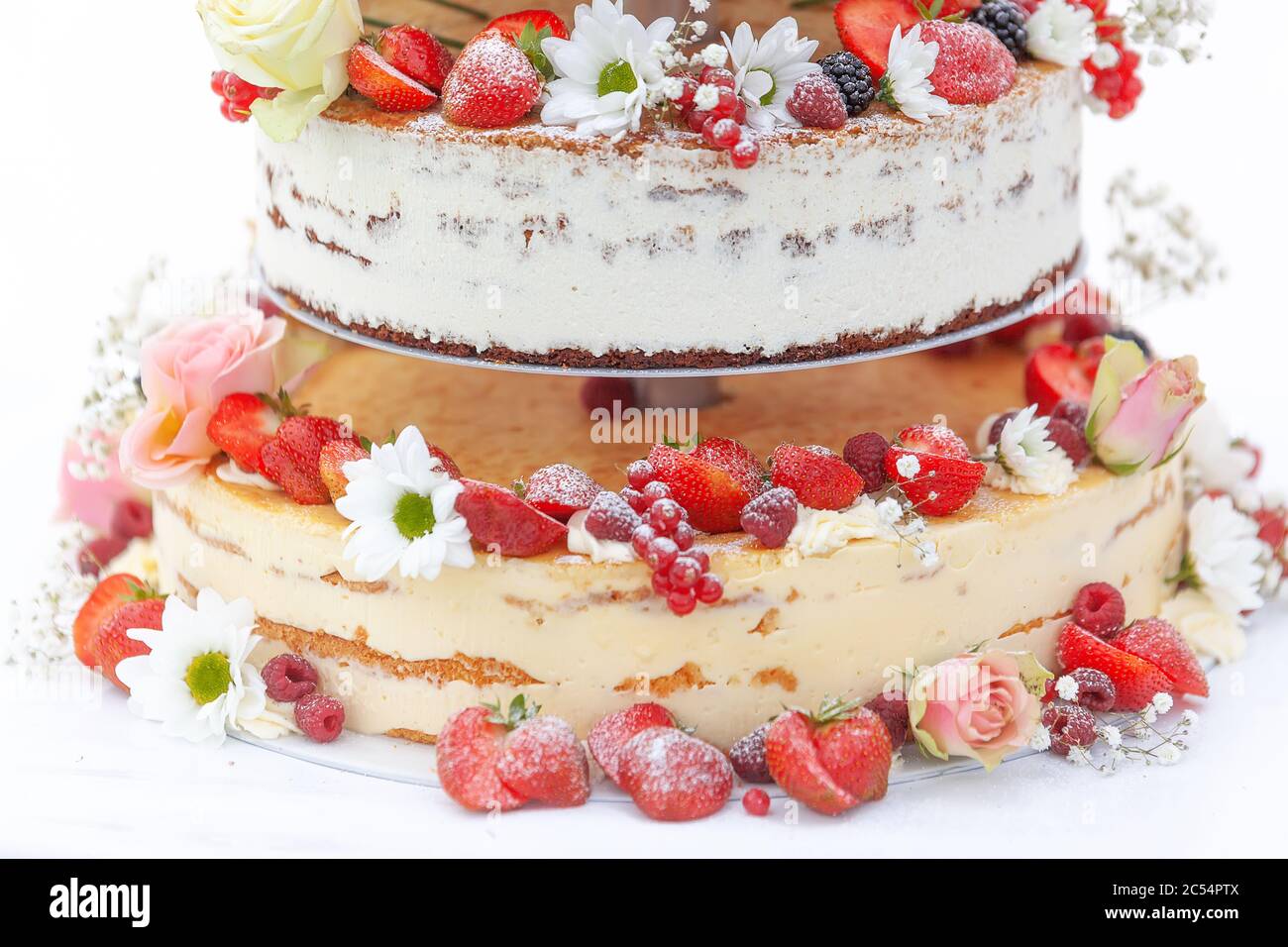 Particolare di un esclusivo dolce di nozze di frutta, colorato decorato con molta frutta e fiori. Foto Stock