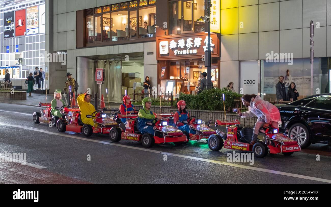 Turisti stranieri che guidano affittato go kart in via Shibuya, Tokyo, Giappone Foto Stock