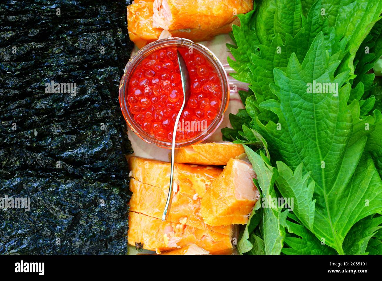 Piatto sano con salmone al forno, uova di salmone, cetriolo, foglie di shiso e nori Foto Stock