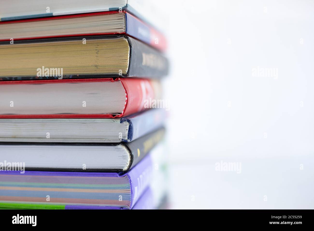 Impilati vecchi libri dal lato della copertina, messa a fuoco morbida, primo piano. Imparare, leggere, avventura di curiosità. Foto Stock