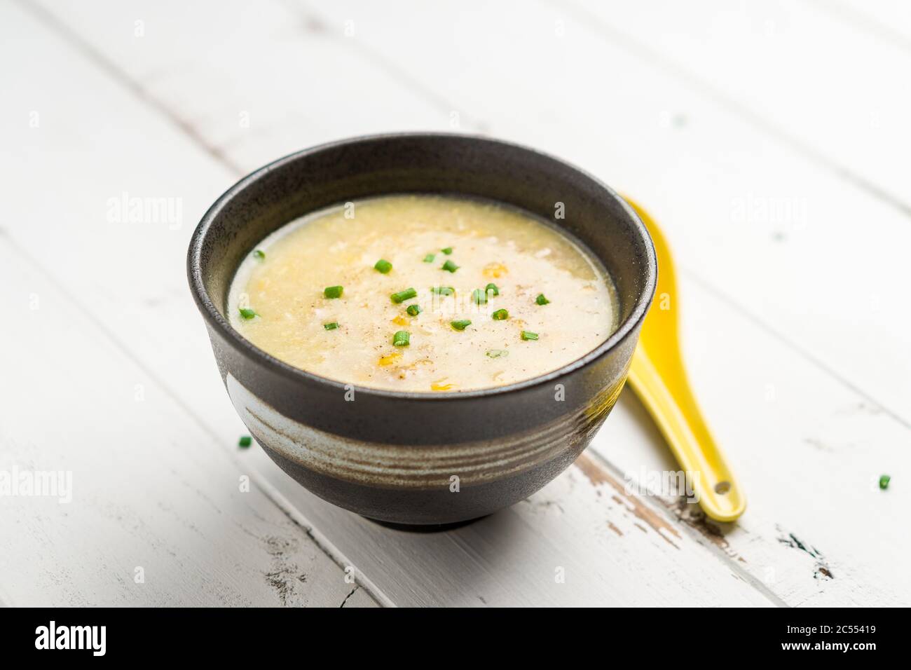 Zuppa di mais su sfondo bianco. Un piatto di cucina Cantonese spesso servito come antipasto nei ristoranti cinesi. La ciotola della zuppa è su sfondo bianco. Foto Stock