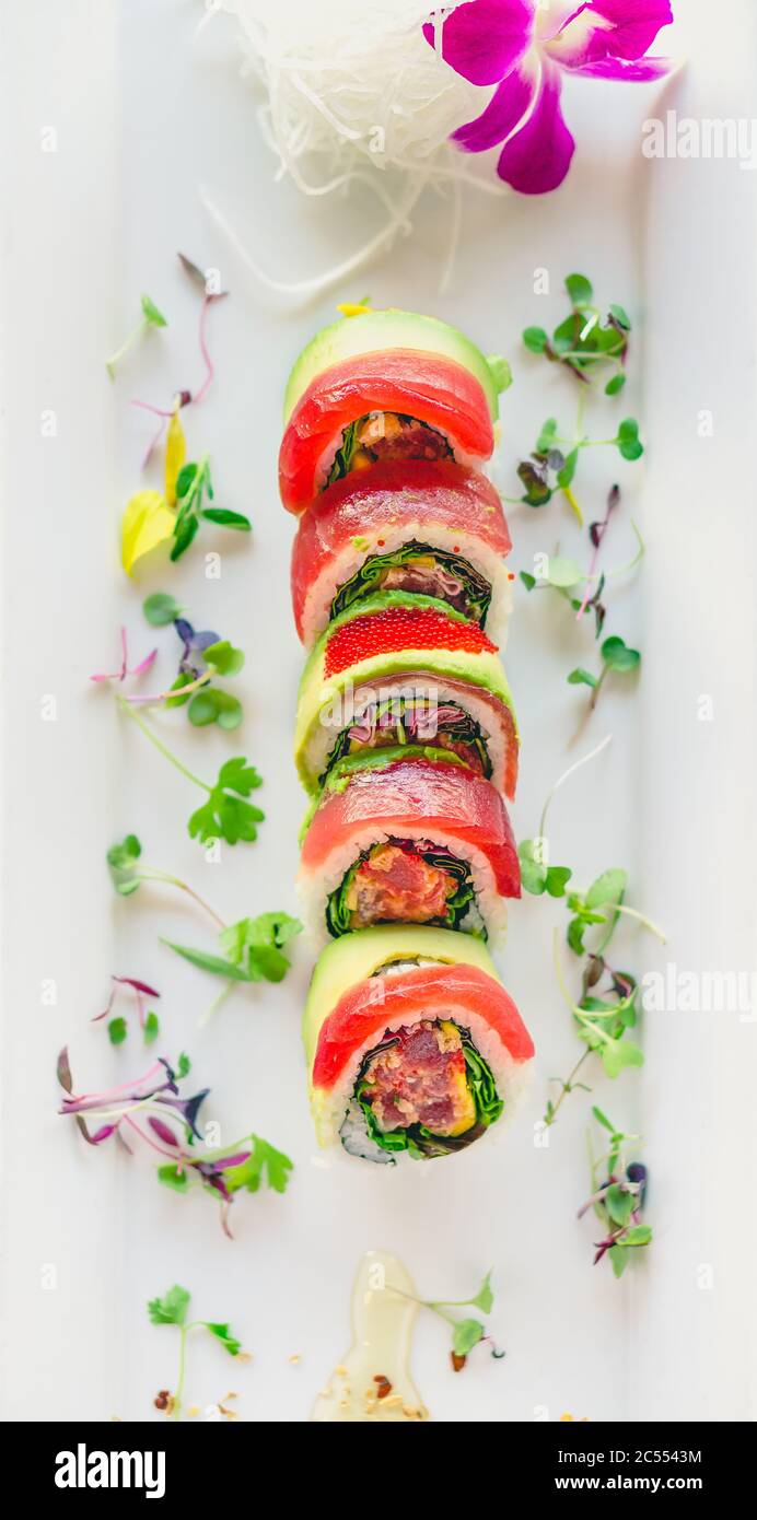 Vista dall'alto del tonno Maki sushi. Un sushi in stile uramaki su un piatto bianco. Il pesce e il riso sashimi crudi sono all'esterno mentre nori è all'interno. Questo Foto Stock