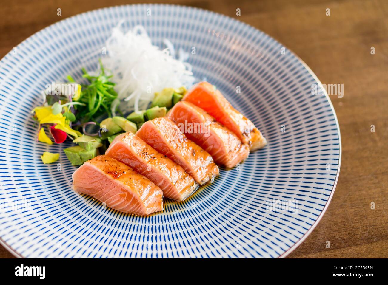 Piatto sano tataki di salmone crudo. Fette di salmone di grado sashimi scottate leggermente per mantenere il pesce crudo all'interno. Si tratta di una tecnica di cucina Giapponese che Foto Stock