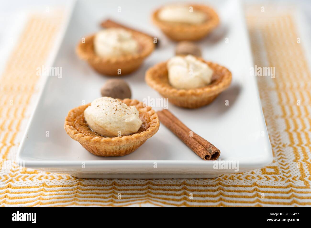 Primo piano con torta al burro dolce. Mini torte di zucchero (o crostate di burro) con una crosta di pasta frizzante, un ripieno dolce e crema di spezie di zucca montata sopra. A te Foto Stock