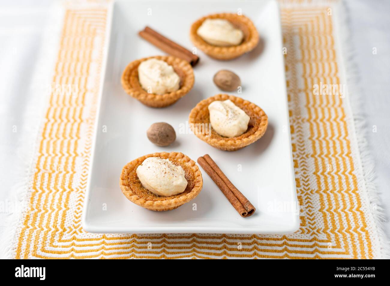 Mini crostata di burro con crema. Mini torte di zucchero (o crostate di burro) con una crosta di pasta frizzante, un ripieno dolce e crema di spezie di zucca montata sopra. Una ta Foto Stock