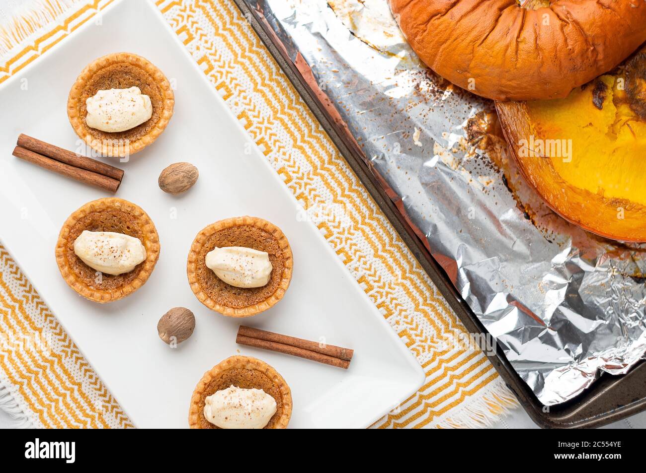 Vista dall'alto della torta di zucchero di zucca. Mini torte di zucchero (o crostate di burro) con una crosta di pasta frizzante, un ripieno dolce e crema di spezie di zucca montata sopra. Una ta Foto Stock