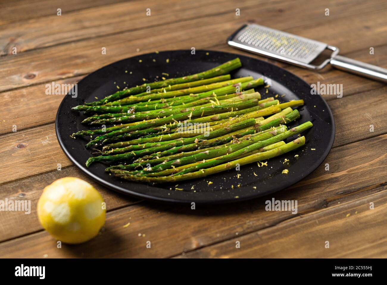 Asparagi vegetariani arrostiti. Mangiare cibo sano è facile con questo piatto di vegan fatto in casa; asparagi arrosto con scorza di limone in cima. I veggies sono ser Foto Stock