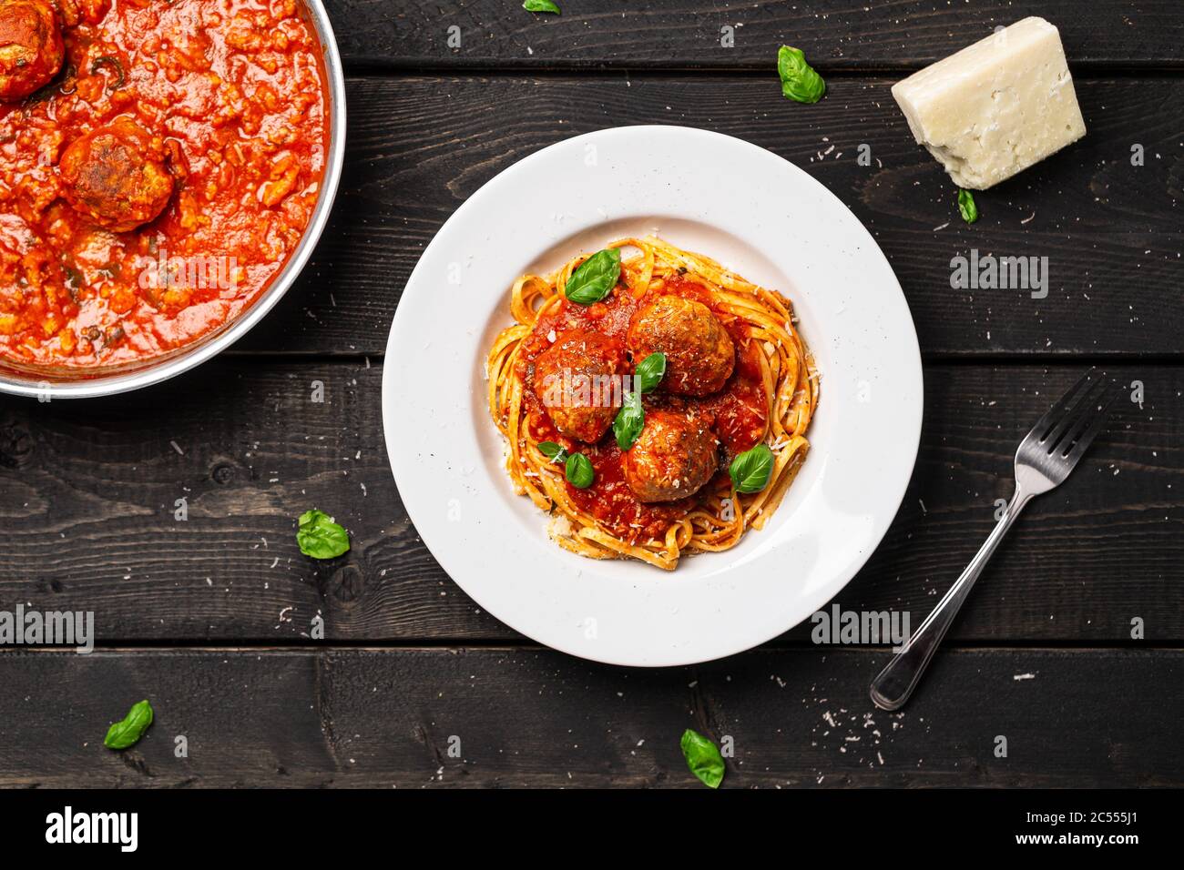 Vista dall'alto della piastra spaghetti e polpette. Piatto di pasta italiana servito in piatto bianco su fondo di legno nero. Spaghetti e polpette sono come bolognesi Foto Stock