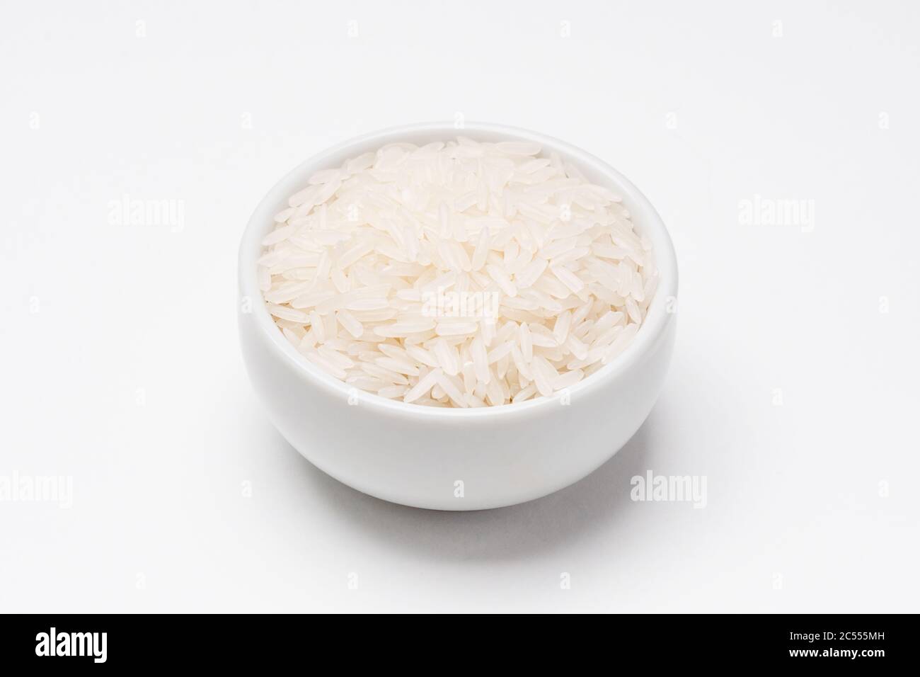 Ciotola di riso Jasmine su sfondo bianco. Il riso proviene da semi di erba, è l'ingrediente di alimento di base più consumato. Il riso Jasmine è un tipo di fraga Foto Stock