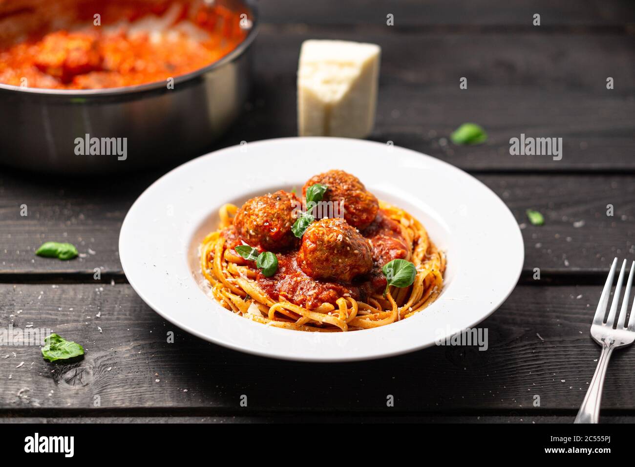 Spaghetti piatto di meatball foto stock. Piatto di pasta italiana servito in piatto bianco su fondo di legno nero. Spaghetti e polpette sono come bolognesi Foto Stock