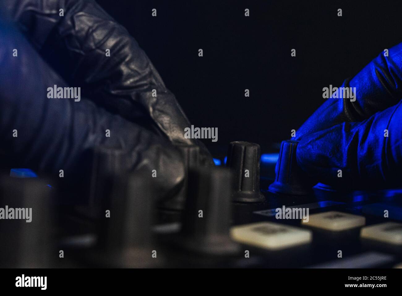 DJ cambiare la musica sulla sua tavola con guanti neri Foto Stock